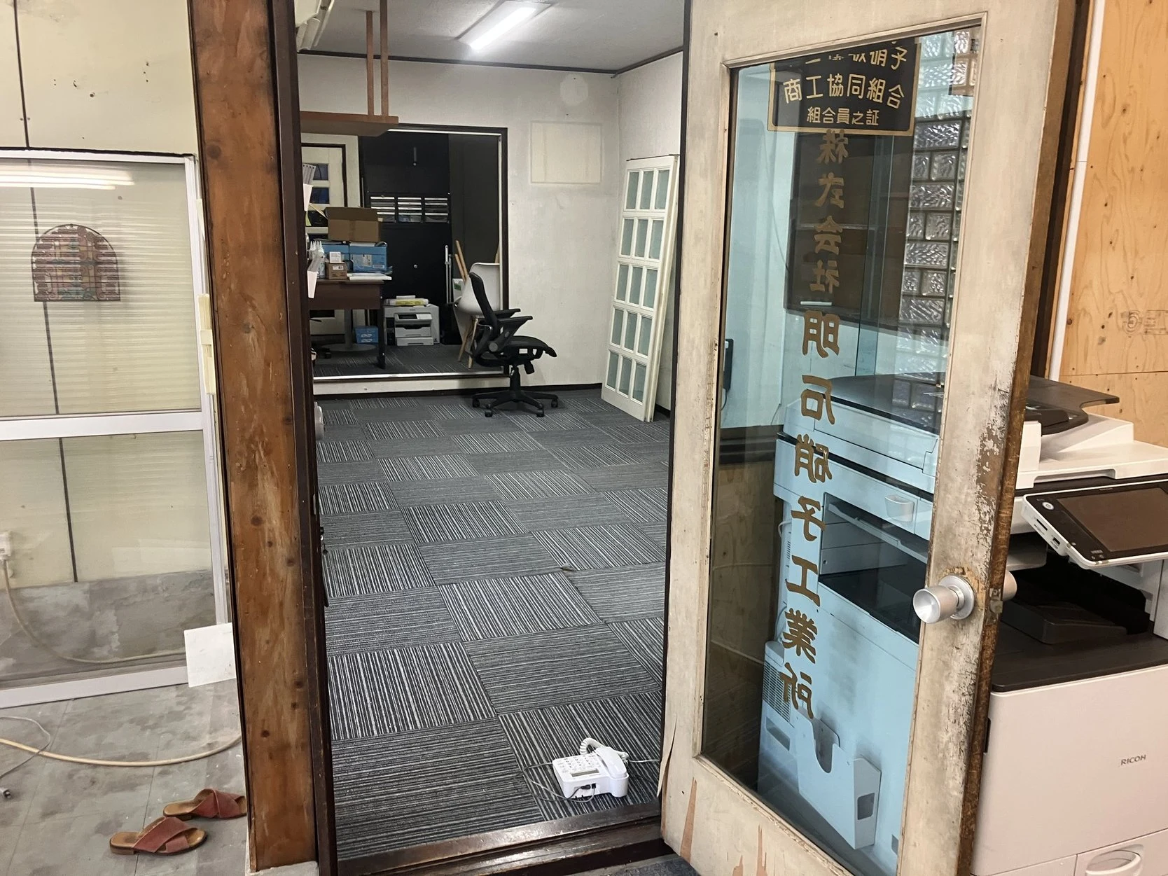 新社屋事務所入口の木製建具と金文字硝子